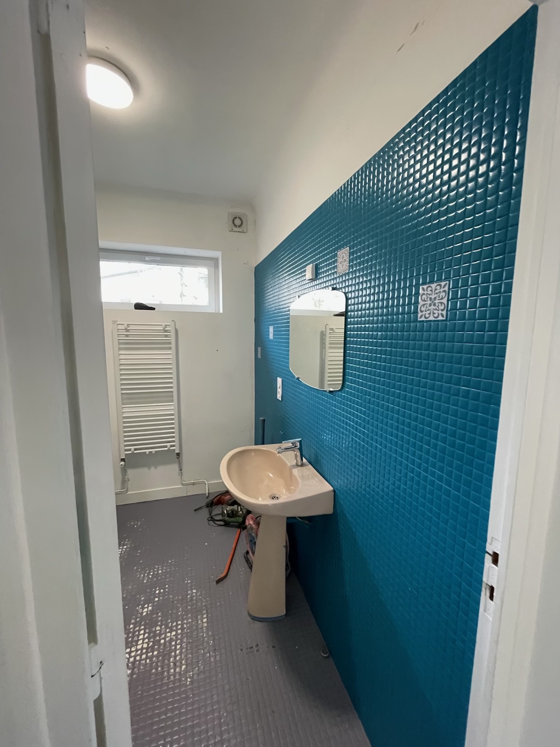 Avant — carrelage bleu et lavabo sur pied